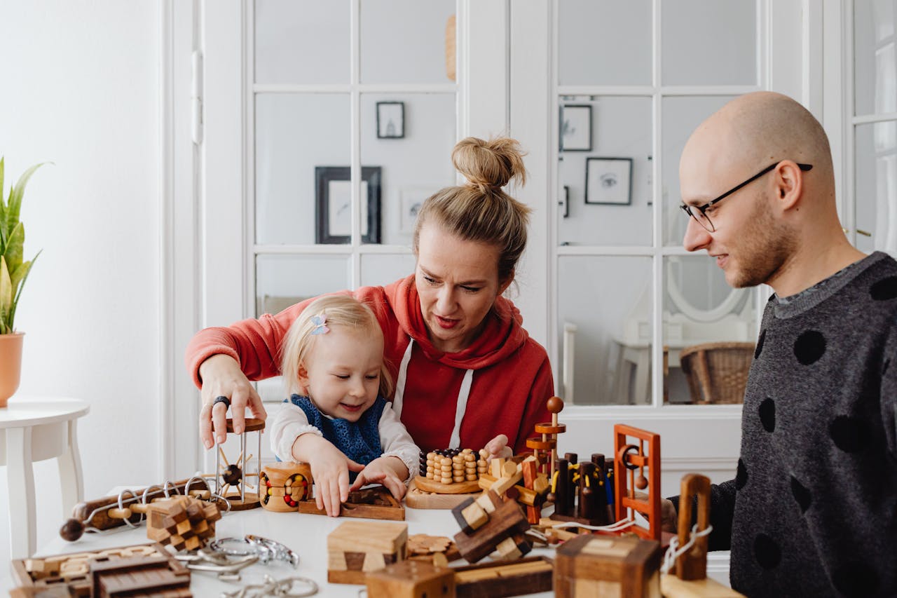 A family enjoying time together playing with educational wooden toys indoors. Warm and candid interaction.
